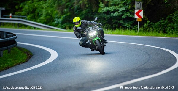 Při průjezdu zatáčkou na motocyklu: Zůstávají obě dvě nohy na stupačkách.