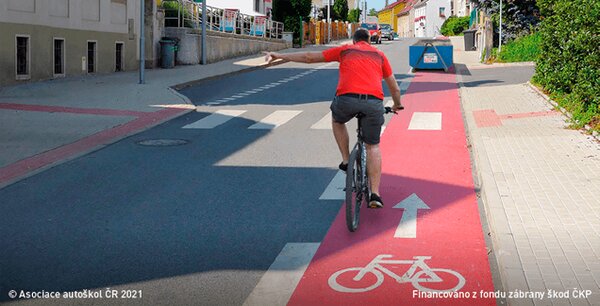Cyklistovi, který dává znamení o změně směru jízdy proto, aby mohl přejet z vyhrazeného…